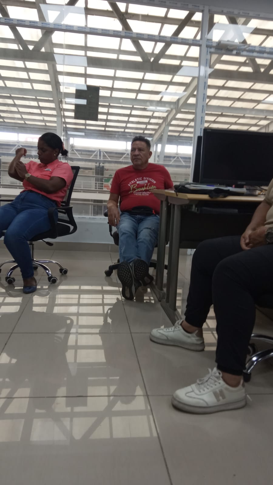 Ciro Hernández y Belén Mejía durante el conversatorio — Ciro con camisa roja, Belén al fondo con uniforme rosa INADEH